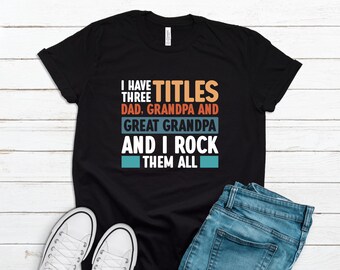 May include: Black t-shirt with a vintage-style graphic that reads "I have three titles: Dad, Grandpa and Great Grandpa and I rock them all".