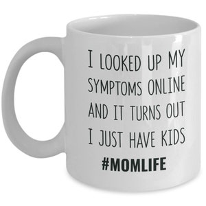 May include: White ceramic coffee mug with black text that reads "I looked up my symptoms online and it turns out I just have kids #momlife".