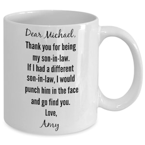 May include: White ceramic coffee mug with black text that reads "Dear Michael, Thank you for being my son-in-law. If I had a different son-in-law, I would punch him in the face and go find you. Love, Amy."