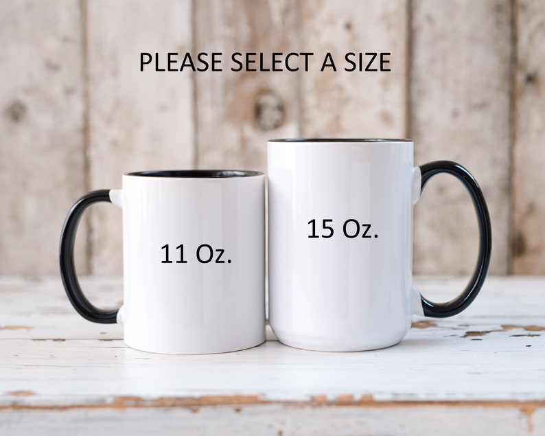 May include: Two white ceramic mugs with black handles and black rims. The mug on the left is 11 oz and the mug on the right is 15 oz.