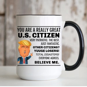 K&ouml;nnte beinhalten: Eine wei&szlig;e Keramik-Kaffeetasse mit schwarzem Rand und Henkel. Die Tasse zeigt eine Schwarzwei&szlig;illustration eines Mannes mit roter Krawatte und dem Text "YOU ARE A REALLY GREAT U.S. CITIZEN VERY PATRIOTIC. THE BEST. JUST FANTASTIC. OTHER CITIZENS? YUUGE LOSERS! TOTAL DISASTERS! EVERYONE AGREES. BELIEVE ME."
