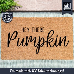 Könnte beinhalten: Eine braune Kokosmatte mit dem Text "HEY THERE Pumpkin" in schwarzer, kursiv geschriebener Schrift. Die Matte ist mit UV Stick Technologie hergestellt.