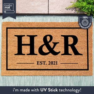 May include: A brown coir doormat with black trim and the letters "H&R" in black, along with the text "EST. 2021".