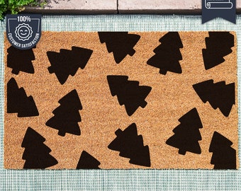 May include: A brown coir doormat with a repeating pattern of black Christmas trees. The mat has the text "i'm made with UV Stick technology!" printed on the bottom.