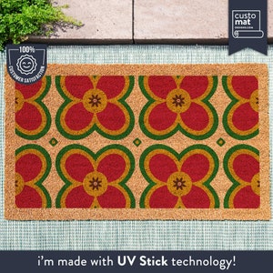 May include: A brown coir doormat with a repeating pattern of red, yellow, and green stylized flowers. The text "i'm made with UV Stick technology!" is printed below the mat.