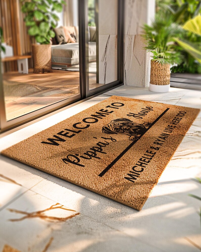 K&ouml;nnte beinhalten: Rechteckige Fu&szlig;matte aus Naturfasern. Der Schriftzug "WELCOME TO Pippa's House" mit einer Mops-Illustration ist zu sehen. Darunter steht "MICHELLE & RYAN LIVE HERE TOO" in schwarzer Schrift.