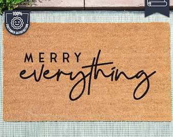 May include: A brown coir doormat with the text "Merry everything" in black script font. The mat is made with UV Stick technology.