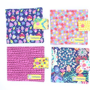 May include: Four colorful fabric items with unique patterns. One features fish, another stars, a third a geometric design, and the last a floral motif. Each has a small tag with the text "Sunshiningmoon."
