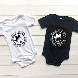 May include: Two baby onesies, one white and one black, with a black and white graphic design of a crown and the text "Mockup Queen Premium Mockups".
