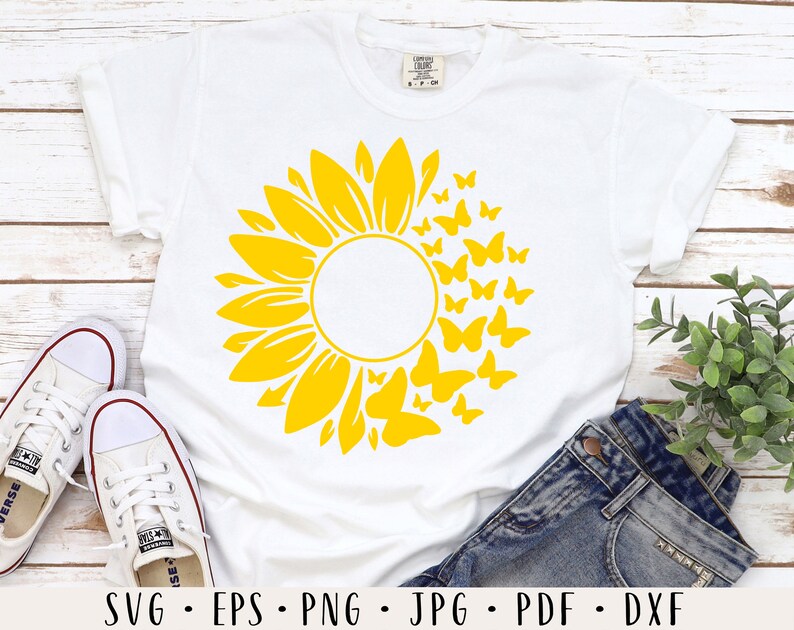 Peut inclure: T-shirt blanc avec un motif de tournesol jaune et un cercle au centre. Des papillons entourent le tournesol. Le texte "SVG - EPS - PNG - JPG - PDF - DXF" est en bas de l'image.