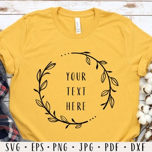 May include: A yellow t-shirt with a black floral wreath design and the text "YOUR TEXT HERE" in the center.