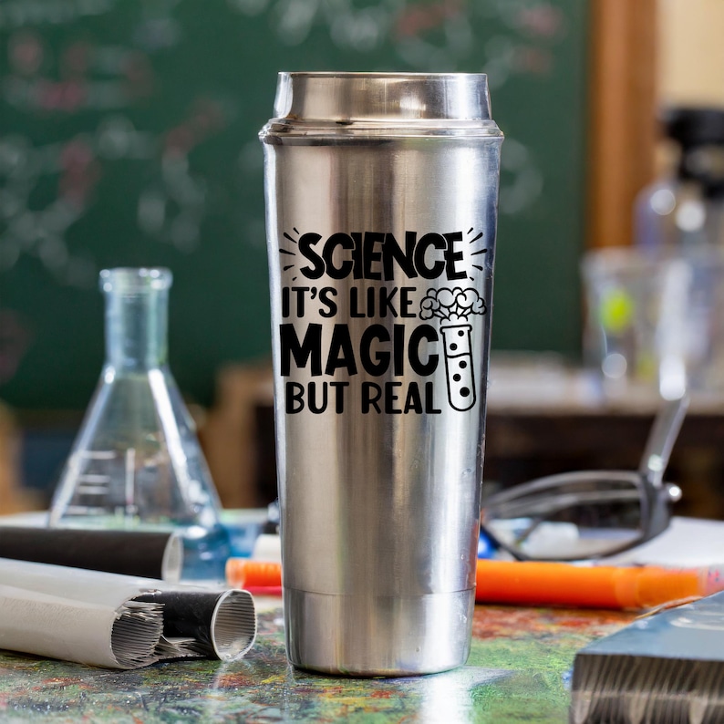 May include: A stainless steel travel mug with a black graphic that reads "Science it's like magic but real" with a cartoon beaker and smoke coming out of the top.