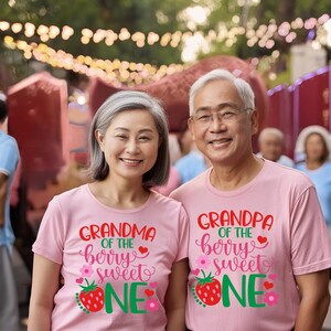Puede incluir: Una pareja lleva camisetas rosas con un gr&aacute;fico de fresa y el texto "Abuela de la baya dulce" y "Abuelo de la baya dulce".