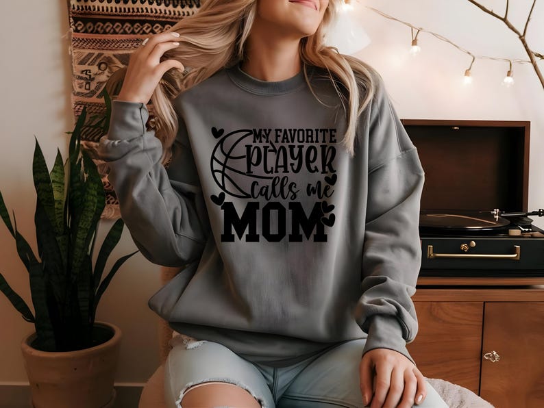 May include: Gray sweatshirt with black text that reads "My favorite player calls me MOM" with a basketball graphic and hearts.