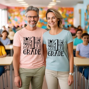 May include: Two people wearing light pink and light blue t-shirts with black text that says "FIRST" and "GRADE" with the number "1" in the center.