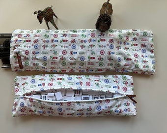 May include: Two fabric Mahjong tile cases with a cream background and a repeating pattern of red, blue, and green floral and geometric designs. One case is open, revealing white tiles. The cases have brown zipper pulls.