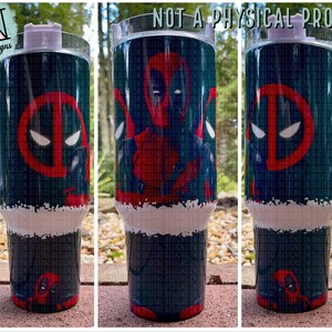 May include: A tumbler featuring a Deadpool design. The tumbler has a white handle and lid, with a teal background and a red and white Deadpool graphic. The text "NOT A PHYSICAL PRODUCT" is at the top.