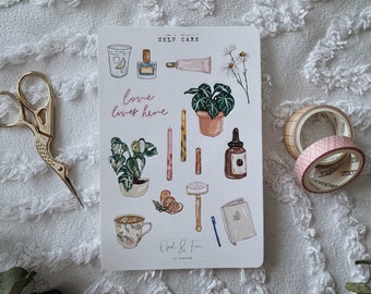 May include: A sheet of stickers with illustrations of self-care items, including plants, candles, a glass of water with lemon, a bottle of perfume, a tube of hand cream, a razor, a notebook, a cup of tea, and a bottle of essential oil. The stickers are on a white background and have the text "Self Care" and "Love lives here" in pink.