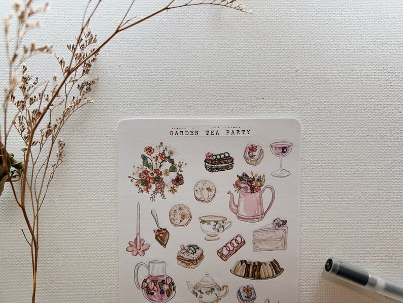 May include: A sheet of stickers featuring a garden tea party theme. The stickers are illustrated in a watercolor style and include images of teacups, teapots, cakes, pastries, flowers, and a cocktail glass. The text "GARDEN TEA PARTY" is printed at the top of the sheet.