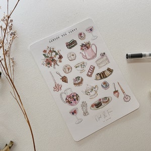 May include: A sheet of stickers featuring a watercolor illustration of a garden tea party. The stickers include images of teacups, teapots, cakes, pastries, flowers, and a hand holding a teacup. The text "Garden Tea Party" is at the top of the sheet, and the text "Opal & Fern" is at the bottom.