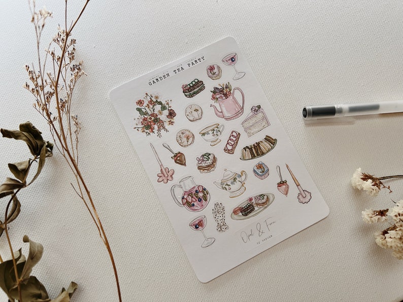 May include: A sheet of stickers featuring a watercolor illustration of a garden tea party. The stickers include images of teacups, teapots, cakes, pastries, flowers, and a hand holding a teacup. The text "Garden Tea Party" is at the top of the sheet, and the text "Opal & Fern" is at the bottom.