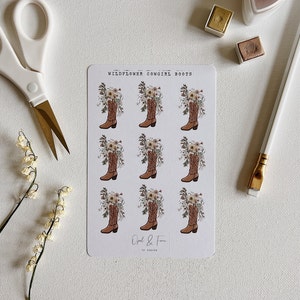 Op de afbeelding: Een vel stickers met negen illustraties van cowboylaarzen gevuld met wilde bloemen. De tekst "Wildflower Cowgirl Boots" en "Opal & Fern" staat op het vel gedrukt.
