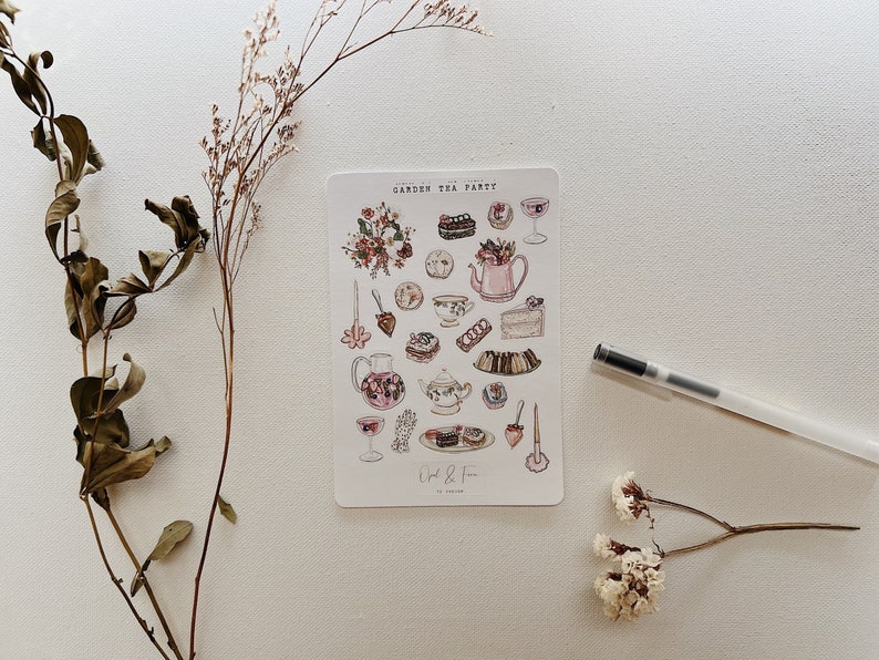 May include: A sheet of stickers with illustrations of tea party items, including teacups, teapots, cakes, and pastries. The stickers are on a white background and have a pink and brown color scheme. The text "Garden Tea Party" is at the top of the sheet.