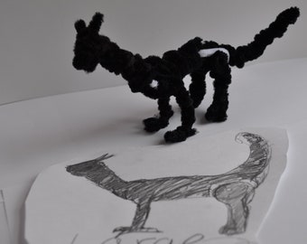 May include: A black pipe cleaner dragon sculpture with white accents. The dragon is posed on a white surface with a pencil drawing of a larger dragon underneath it. The drawing is labeled "Large".