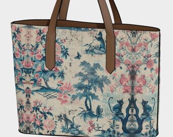 May include: A large tote bag with brown leather handles and a floral print featuring pink and blue flowers, trees, and cats. The print has a vintage aesthetic.