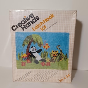 May include: Creative Hands Latch Hook Kit with a panda and tiger design on a blue background. The kit includes pre-cut yarn, a printed canvas, and instructions. The finished rug size is 24 x 34 inches.
