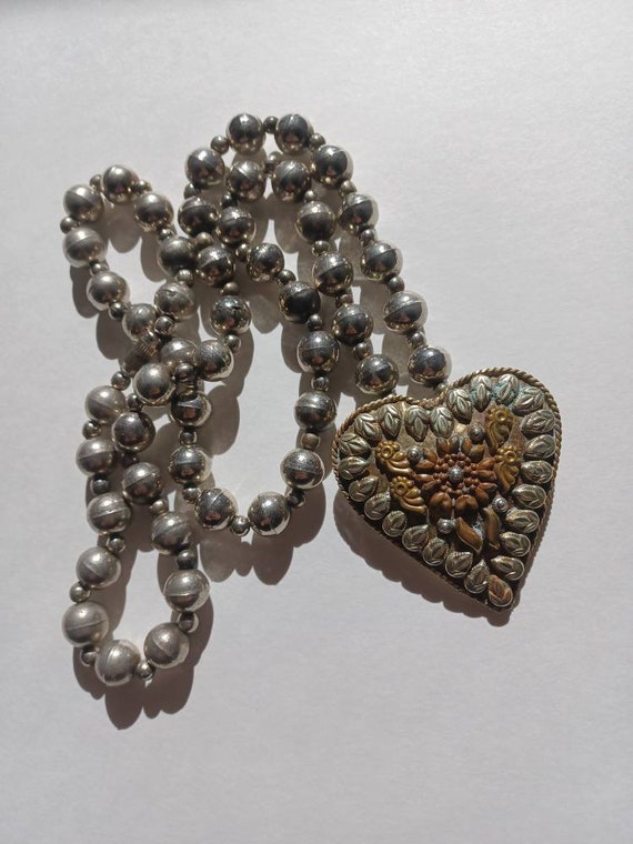 Heart shaped brooch with metal bead necklace