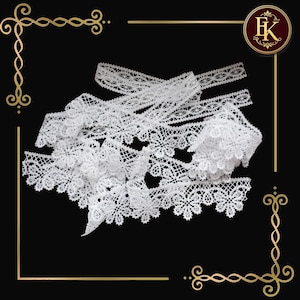 May include: A collection of white lace trim with intricate floral and geometric patterns. The lace is arranged on a black background, showcasing its delicate details. The trim is ideal for sewing, crafting, and adding a decorative touch to various projects.
