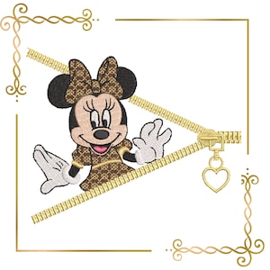 May include: Embroidered Minnie Mouse design in brown and tan with a matching bow and dress. The design includes a gold zipper and a heart-shaped charm, set against a white background with gold decorative borders.