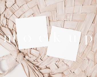 May include: Two blank white cards on a woven straw background. The cards are positioned on top of the straw, with the text "MOCK UP" written in white on the straw.