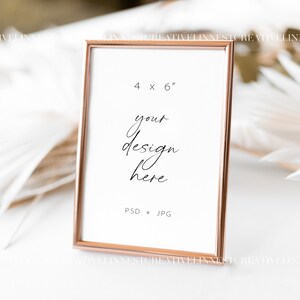May include: A rose gold picture frame with a white mat and a white background. The frame is 4 inches by 6 inches and has the text "your design here" and "PSD + JPG" printed on it.