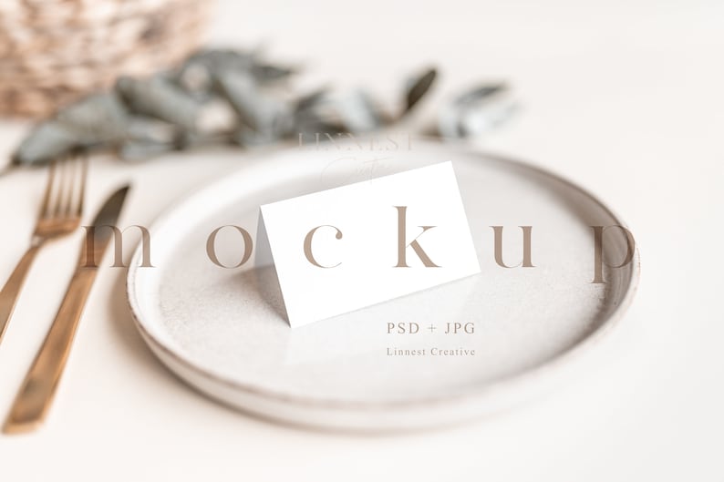 May include: A white blank card mockup on a white plate with gold cutlery and greenery in the background. The text "PSD + JPG" and "Linnesti Creative" is printed on the card.