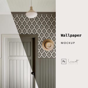 Può includere: Un mockup di un design di carta da parati con un motivo ripetitivo di forme floreali stilizzate in beige e marrone su uno sfondo grigio scuro. La carta da parati è mostrata in una stanza con una porta bianca e un cappello di paglia appeso al muro.