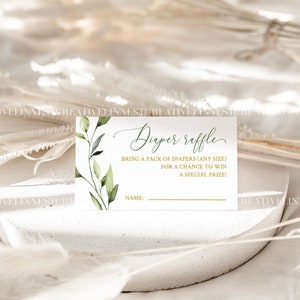 May include: A white card with green foliage and gold lettering. The card says "Diaper Raffle" and "Bring a pack of diapers (any size) for a chance to win a special prize!" There is a line for a name.