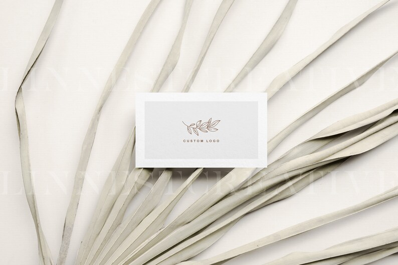 May include: A white card with a simple line drawing of a branch with leaves. The text "CUSTOM LOGO" is printed below the image.