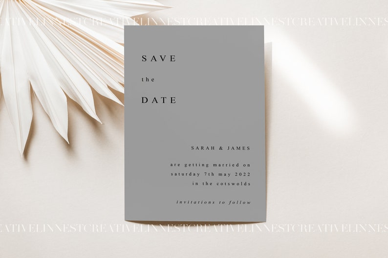 Pu&ograve; includere: Un biglietto di invito grigio con il testo "SAVE the DATE" in caratteri neri. Il biglietto include anche i nomi "SARAH & JAMES" e il testo "are getting married on Saturday 7th May 2022 in the Cotswolds invitations to follow".