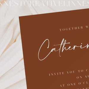 May include: A brown invitation card with white text that reads "Together with their families, Catherine & [unclear text] invite you to celebrate on August 6th at one o'clock in the [unclear text] at [unclear text] Marsh."