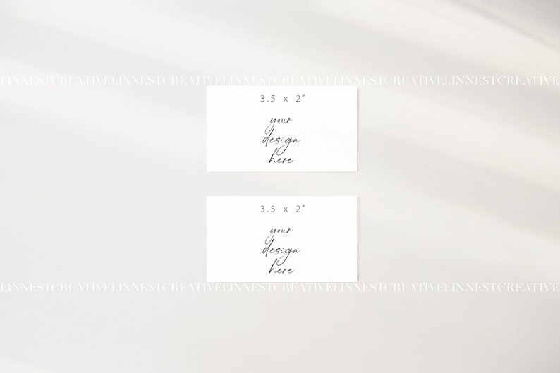 May include: Two blank white cards, each measuring 3.5 inches by 2 inches, with the text "your design here" written in black cursive on each card.
