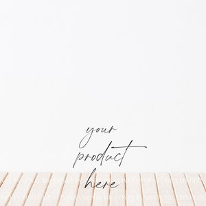 May include: A white wall with a wooden floor. The text "your product here" is written in black cursive on the wall.