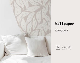 May include: A white sofa with two white cushions in front of a wall with a light pink and white leaf pattern wallpaper. The text "Wallpaper Mockup" is on the right side of the image.