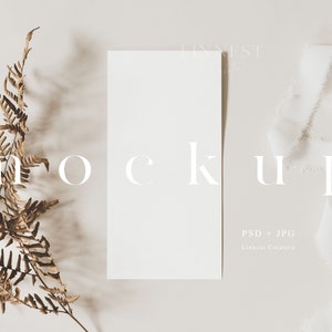 Könnte beinhalten: Ein weißer Karten-Mockup mit einem braunen Farnzweig und einem weißen Band auf einem hellbeigen Hintergrund. Der Text "MOCKUP" ist in Weiß auf die Karte gedruckt. Der Text "PSD + JPG" und "Linnea Creative" ist in Weiß am unteren Rand der Karte gedruckt.