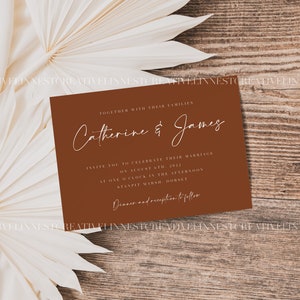 May include: A brown wedding invitation card with white text. The card reads "Together with their families, Catherine & James, Invite you to celebrate their marriage on August 6th, 2022 at one o'clock in the afternoon, Stanpit Marsh, Hornet. Dinner and reception to follow."