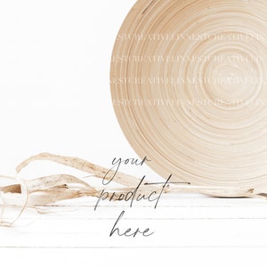 May include: A white wooden surface with a natural woven bowl and dried grass. The text "your product here" is written in black cursive.