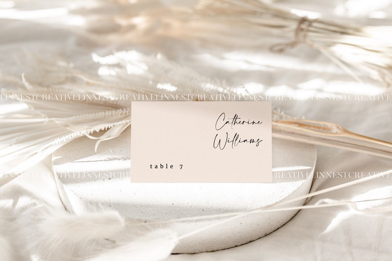 May include: A light pink table card with the text "Catherine Williams" and "table 7" in black font.