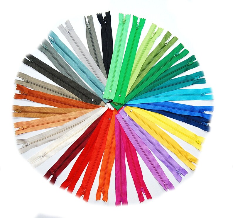 May include: A selection of zipper tapes in a range of colours arranged in a circle. Zipper tape is a common sewing supply used for clothing and other projects.