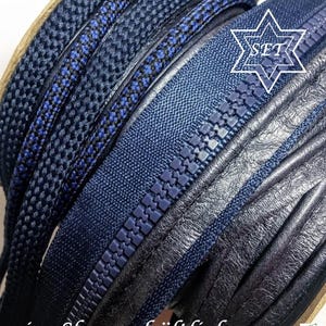 May include: A set of dark blue sewing supplies including a coiled zipper with plastic teeth, a braided cord, and a strip of textured material. A white star-shaped graphic with the text SET is visible, along with the text ...im Shop erh&auml;ltlich.